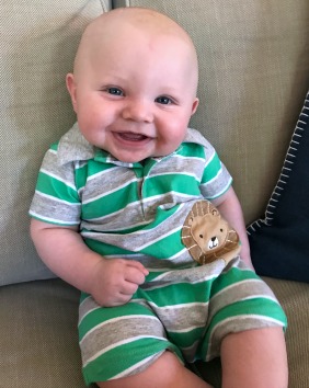 happy baby in green and gray striped onesie