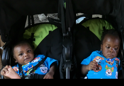 Two baby boys in a twin stroller