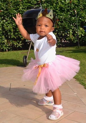 Adopted toddler Ahava wearing a crown and tutu