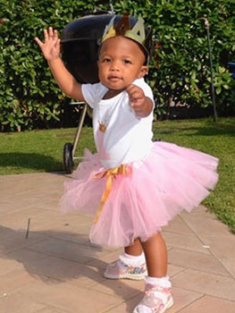 Adopted toddler Ahava wearing a crown and tutu