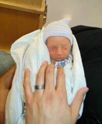 Lifetime adoptive parent holding tiny baby Lucas
