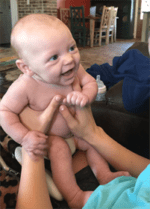 Giggling baby boy being held