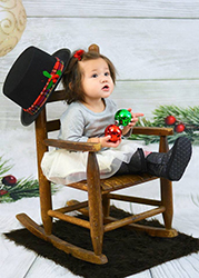girl in rocking chair with Christmas decorations