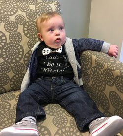 Dan and Hanna's adopted baby boy sits in a chair on adoption finalization day