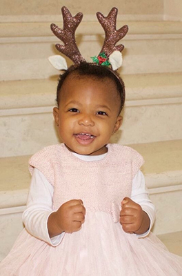Little girl wearing a headband with reindeer antlers