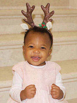 Little girl wearing a headband with reindeer antlers