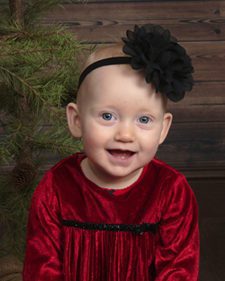 baby with red Christmas dress and black headband