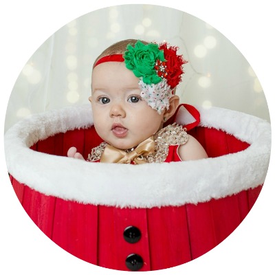 Baby girl in Christmas outfit, inside a Christmas box