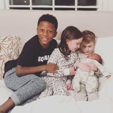 Happy adoptive family embrace their newest sibling