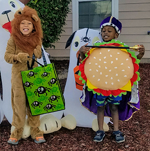 Two children in Halloween costumes: a lion and sandwich