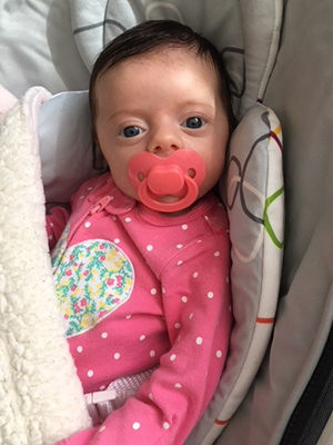 Caucasian baby girl with a pink pacifier