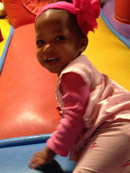 Happy little girl entering bounce house