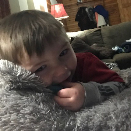 Two-year-old boy cuddles with his stuffed animal