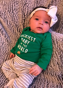 Baby girl dressed in St. Patrick's Day onesie
