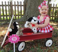Lifetime baby Piper at nine months old, poses for a picture from her wagon