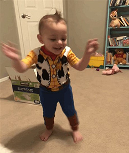 Little boy dancing in a Woody costume