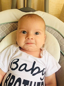 Infant boy wearing a shirt that reads Baby Brother