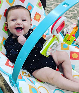 Smiling baby in play chair