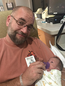 Dad feeding adopted baby at hospital