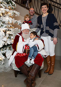 A happy adoptive family and their two children pose with Santa