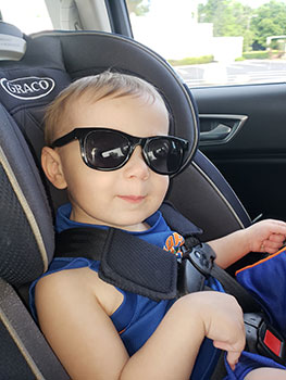 child in car seat with sunglasses