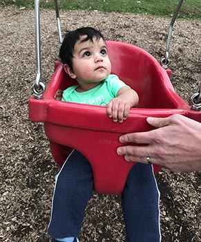 Baby in red swing at park