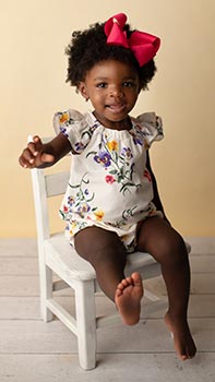 18-month-old African American baby girl sits in a chair