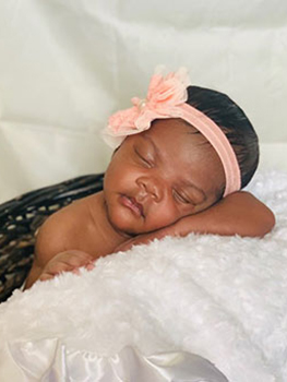 baby girl sleeping with pink bow in her hair