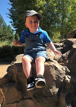 Boy playing on big rocks