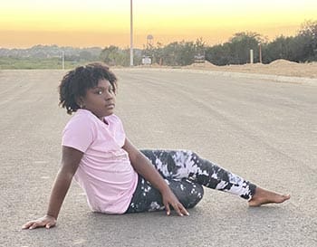 beautiful young African American girl poses on a deserted street
