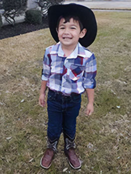 our son smiles at camera with his cowboy hat on