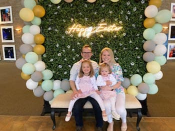 happy family pose under Easter balloon arch