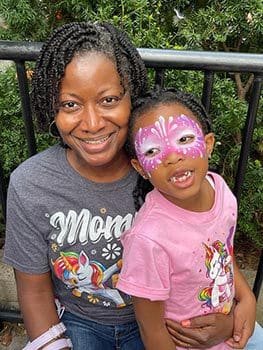 Birthday Princess with painted face smiles in photo with her Mom