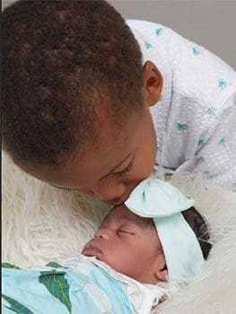 Brother kisses his new sister