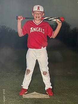 boy in baseball uniform after a game