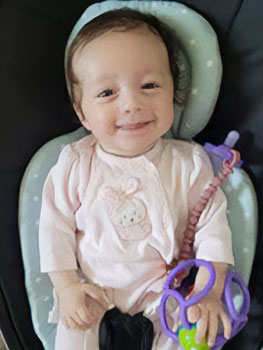 Thriving smiling baby in baby seat