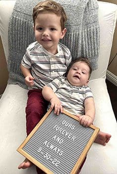 boys together show off a sign about being loved forever