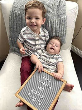 boys together show off a sign about being loved forever