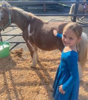 Young girl checking out a pony