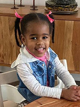 young girl sitting at a desk and smiling