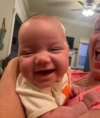 happy baby laughs at the camera