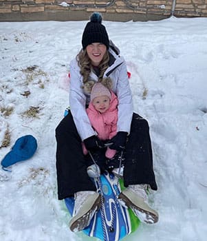 Mom and Carson sledding in the snow